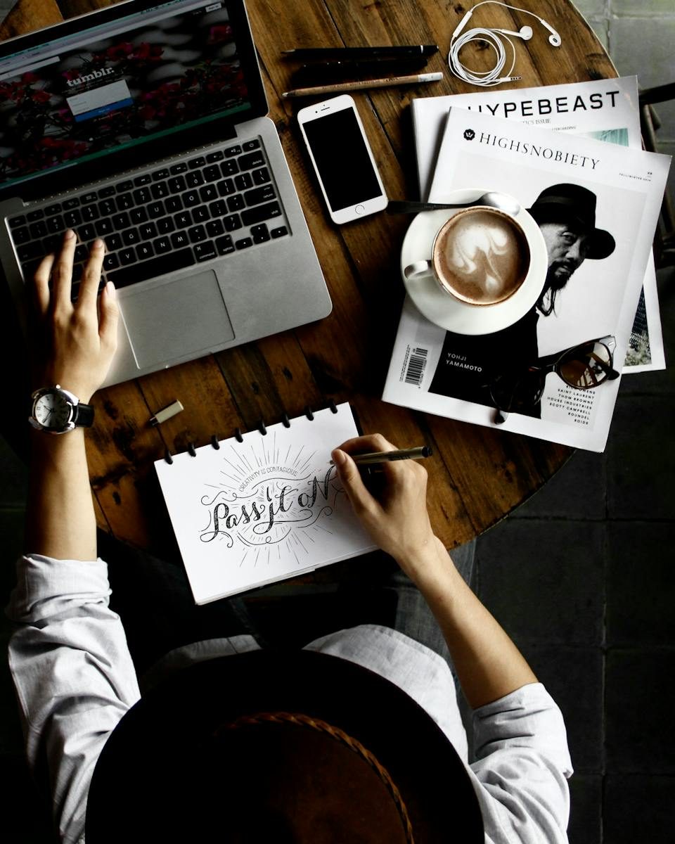 Person Sitting Facing Laptop Computer With Sketch Pad